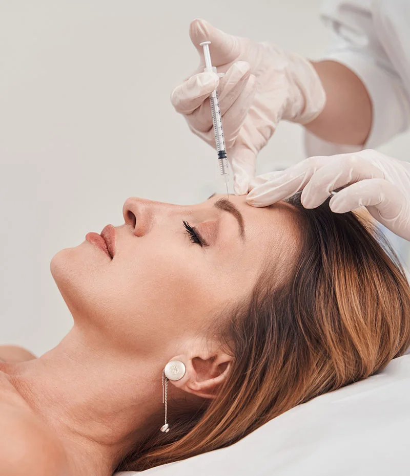 Woman getting dermal filler injections to her forehead