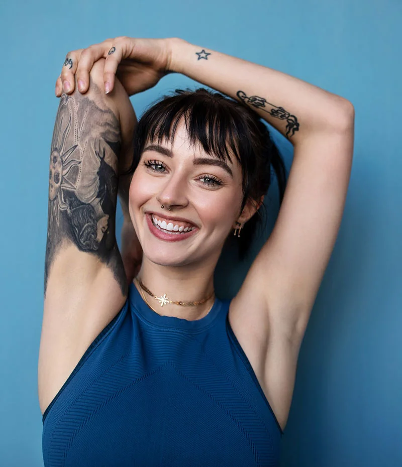 Woman holding her arm up showing her tattoo sleave